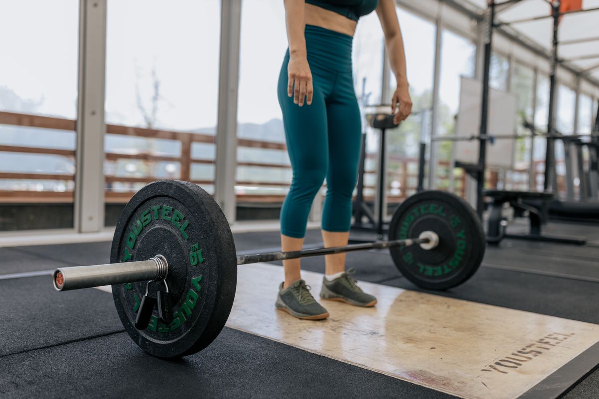 Vrouw voert een deadlift uit met een barbell tijdens krachttraining